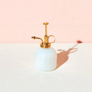 white glass and brass mister